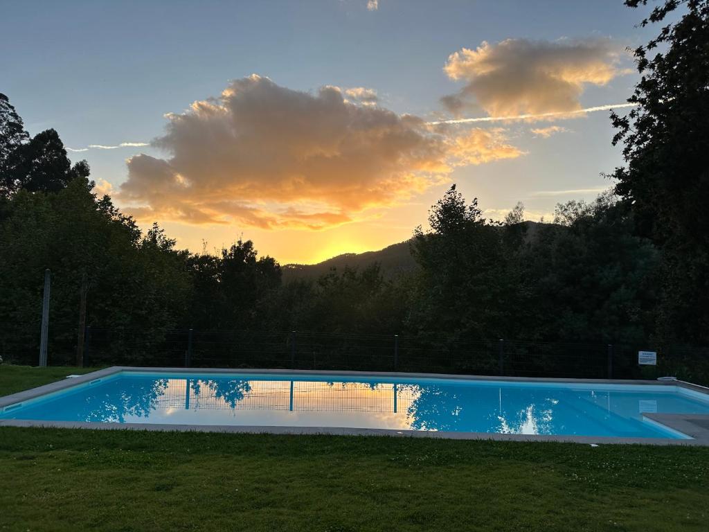 una piscina con puesta de sol en el fondo en Ri&amp;Vale Alojamentos, en Vieira do Minho