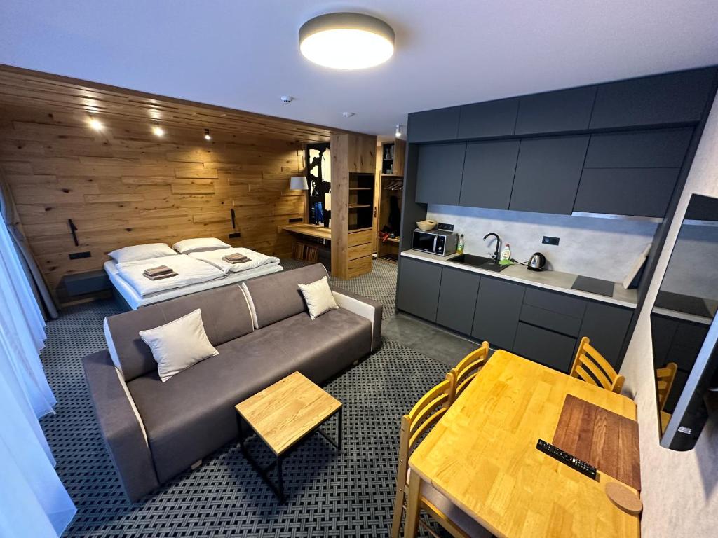 Sala de estar con sofá, cama y mesa en Apartmán u Hromovky en Špindlerův Mlýn