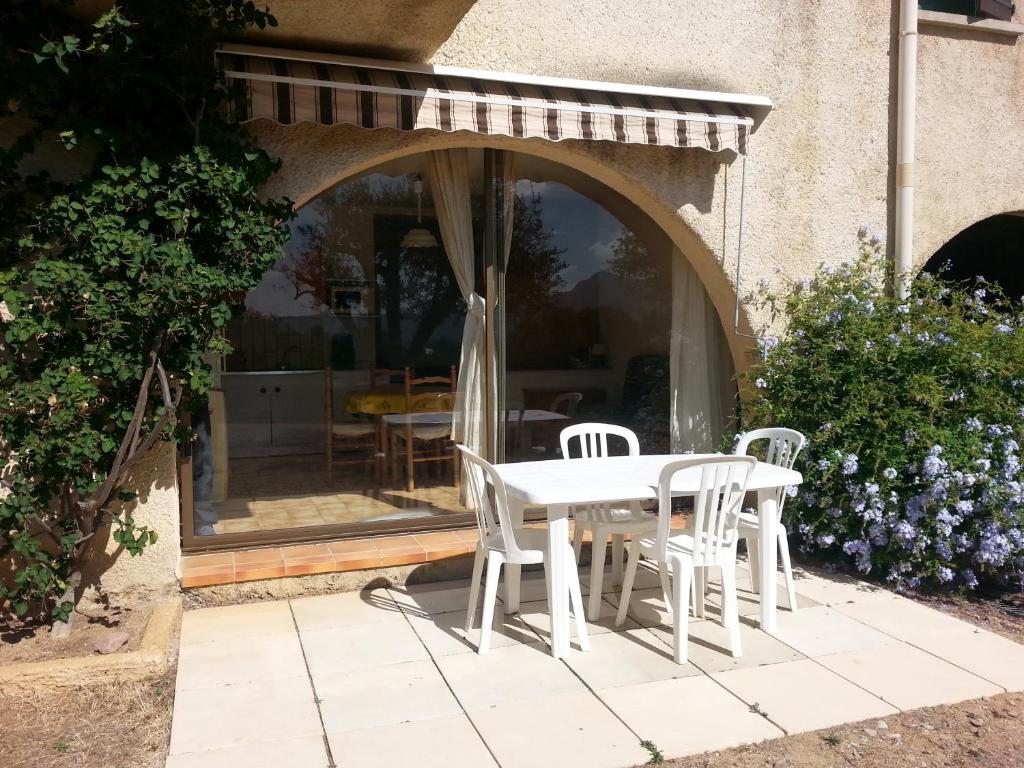 - une table et des chaises blanches sur la terrasse dans l'établissement STUDIO indépendant au calme, à Lumio