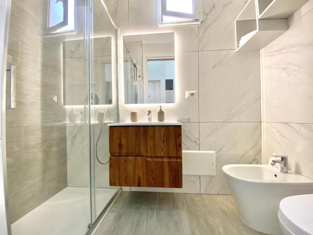 biała łazienka z umywalką i prysznicem w obiekcie La casetta di Marianna w mieście Napoli