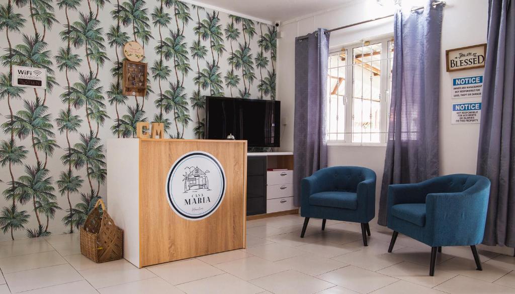 een wachtkamer met 2 stoelen en een televisie bij Casa Maria in Port Louis