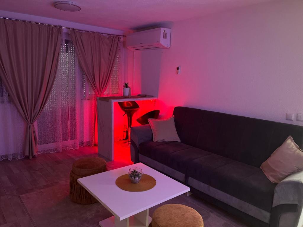ein Wohnzimmer mit einer schwarzen Couch und roten Lichtern in der Unterkunft S-E-N in Bosanski Novi