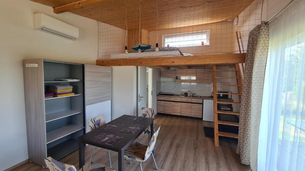 a kitchen and dining room with a loft bed and a table at Orlická přehrada Chata Malá in Kožlí u Orlíka