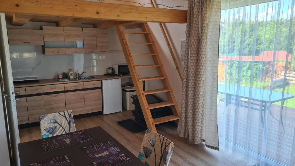 a kitchen with a loft bed and a kitchen with a table at Orlická přehrada Chata Malá in Kožlí u Orlíka
