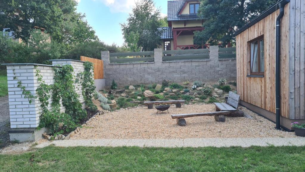a garden with two benches and a fence at Orlická přehrada Chata Malá in Kožlí u Orlíka