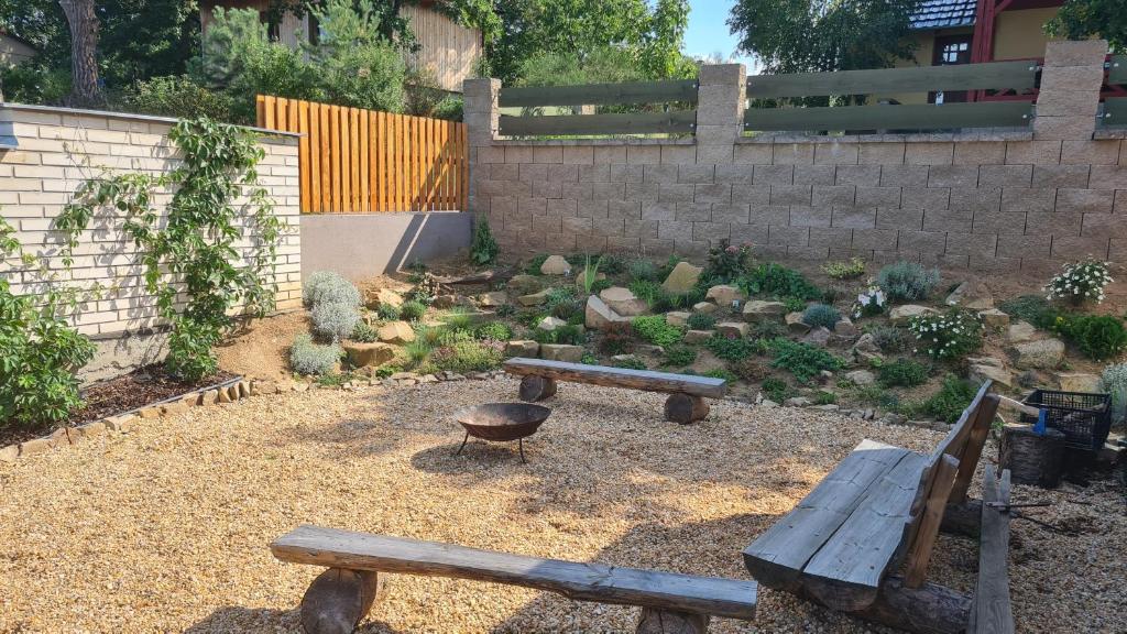 a garden with benches and a grill and a fence at Orlická přehrada Chata Malá in Kožlí u Orlíka