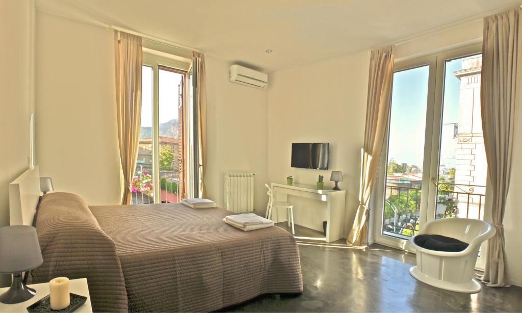 Un dormitorio con una cama y una ventana grande. en Palermo Rooms, en Palermo