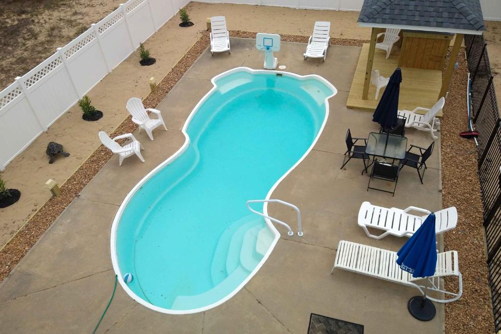 uma vista superior de uma piscina com cadeiras e mesas em 5233 - Surfin Shamrock em Kill Devil Hills