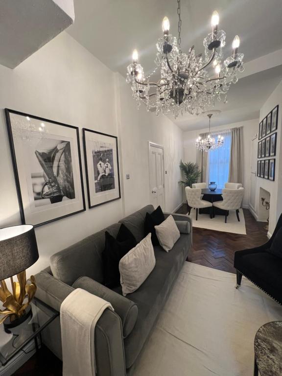 a living room with a couch and a chandelier at Luxury Belfast Stay - Townhouse in Belfast