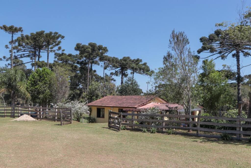 een gebouw met een hek voor een veld bij Chácara do Sapé in São José dos Pinhais