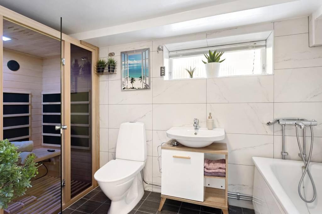 a bathroom with a toilet and a sink and a tub at Vanni´s Bed & breakfast in Malmö
