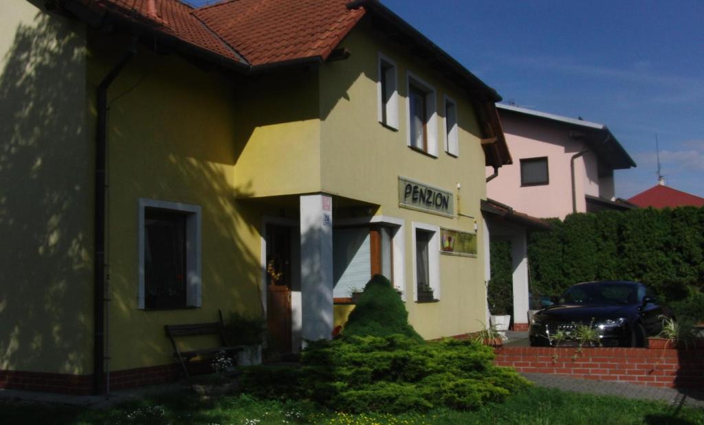 a house with a sign on the side of it at Penzion Ubytování Květinová in Křelov