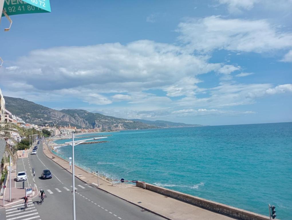 Una vista de una carretera y el océano en un día soleado. en Magnifique 4 COUCHAGES FRONT MER, en Menton