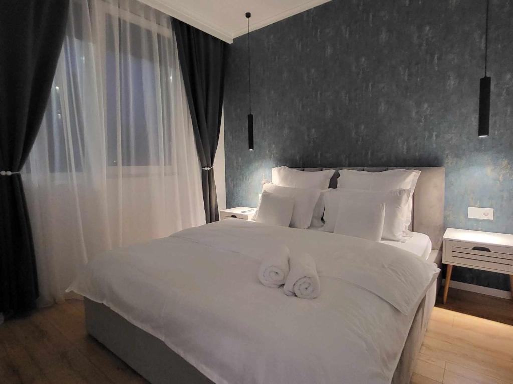 1 dormitorio con 1 cama blanca y 2 toallas en Sika Majestic Apartment en Arad