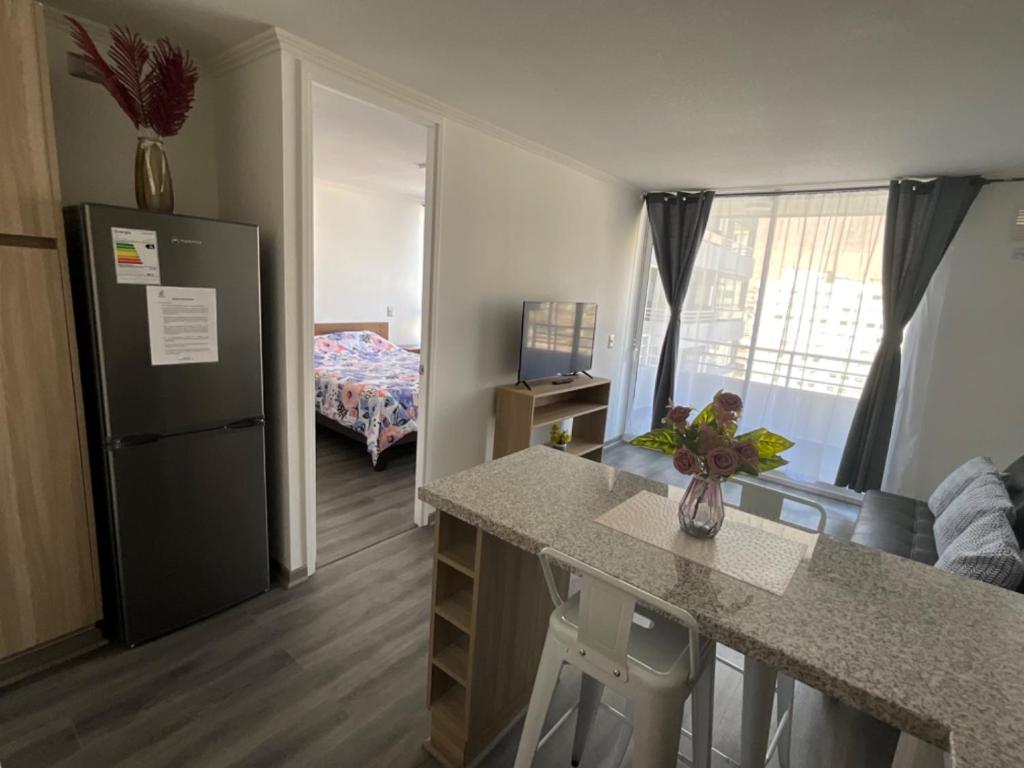 a kitchen with a counter and a refrigerator in a room at Departamento Lynch Iquique in Iquique
