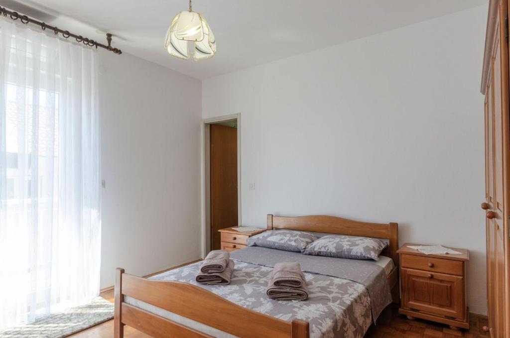 a bedroom with a bed with a dresser and a window at apartmani stefan in Orebić