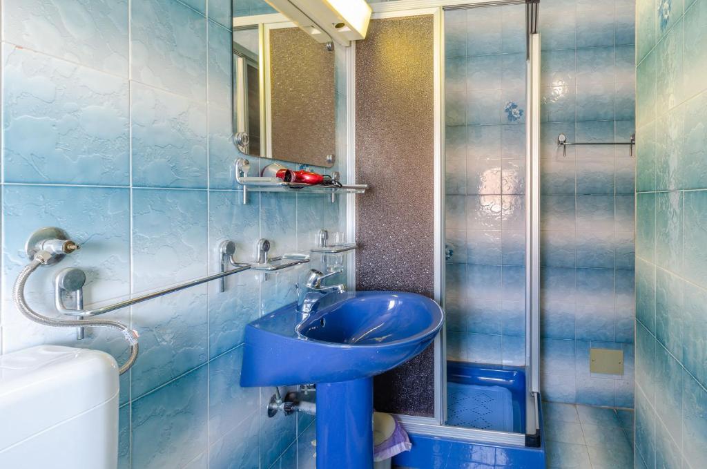 a bathroom with a blue sink and a mirror at apartmani stefan in Orebić