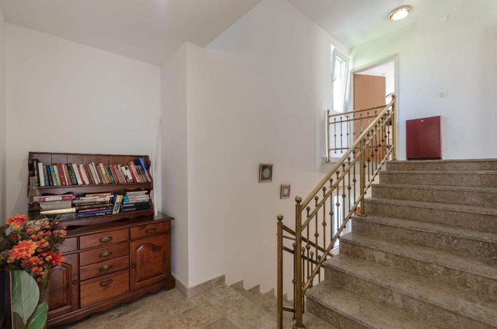 a staircase in a home with a wooden dresser and a book shelf at apartmani stefan in Orebić