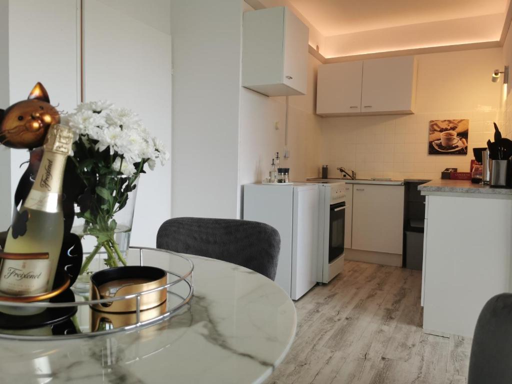 a kitchen and a table with a bottle of champagne at Sweet Home - 3 - in Moers