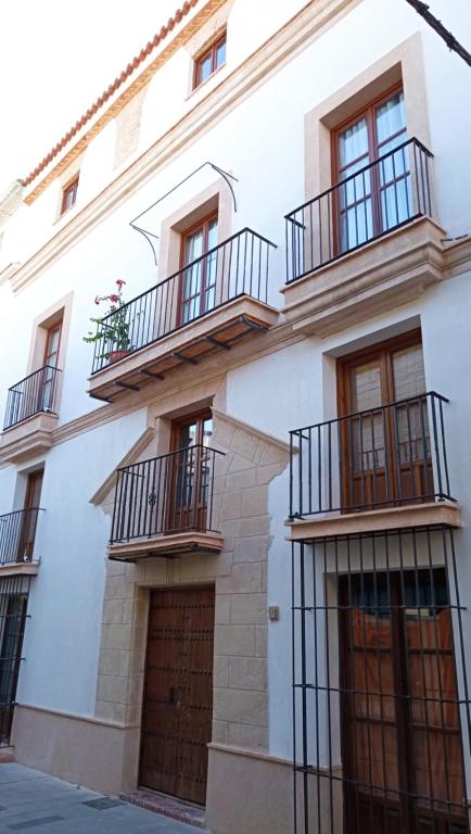 un edificio bianco con balconi e un garage di Hospedería do Porto a El Puerto de Santa María