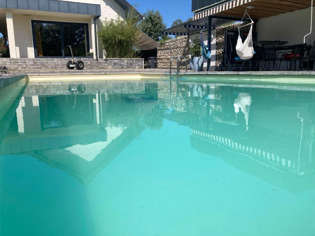una piscina con acqua blu di fronte a una casa di Luxury Zamárdi a Zamárdi
