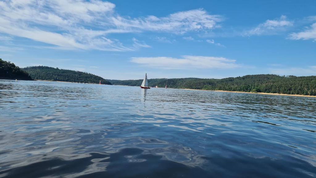 a sailboat on the water on a lake at Orlická přehrada Chata Malá in Kožlí u Orlíka