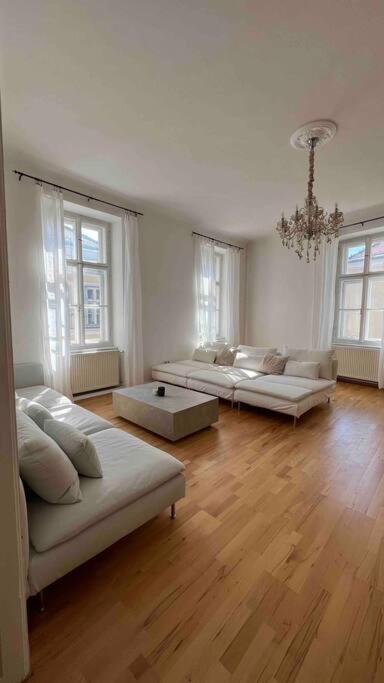 uma grande sala de estar com três sofás em Altbauwohnung im Univiertel! em Graz