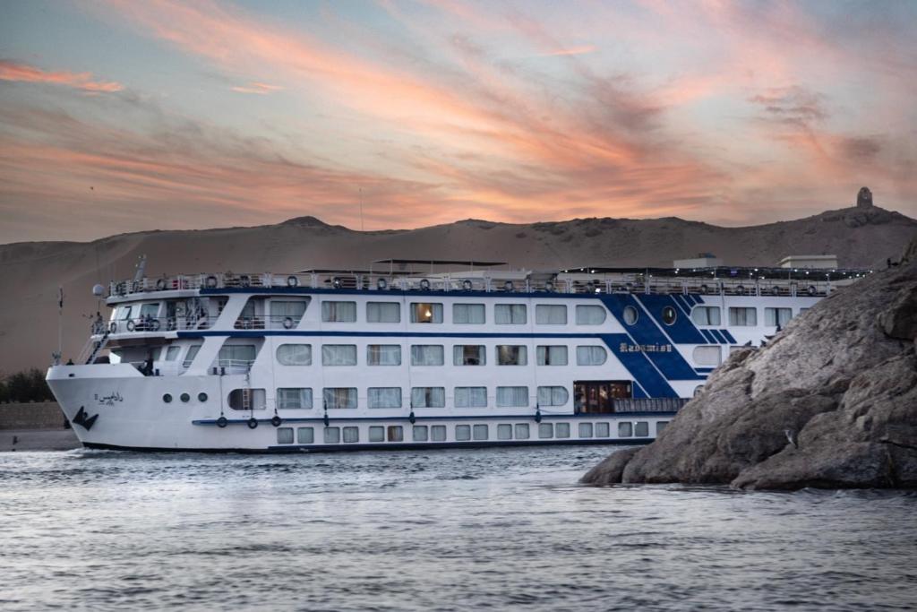 a cruise ship in the water at sunset at 4 Days 3 Nights Nile cruise trip from Aswan to Luxor including Abu Simbel Temples Visit every Monday, Wednesday and Friday in Aswan