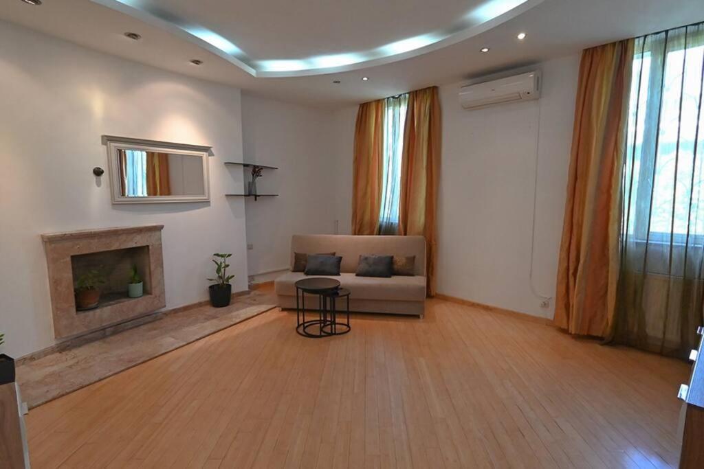 a living room with a couch and a fireplace at Classic apt. on Liberty Square in Tbilisi City