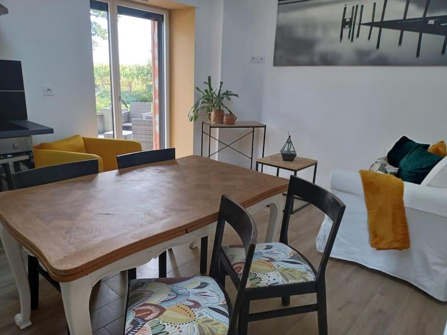 uma sala de estar com uma mesa de madeira e cadeiras em ~ Au calme à la campagne ~ em La Mézière