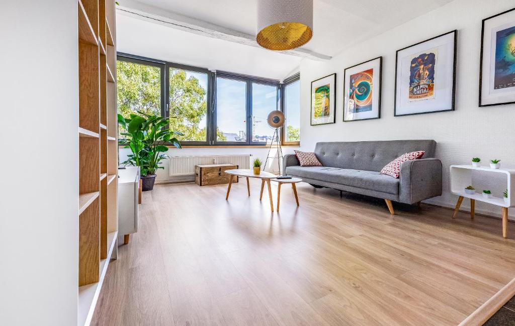 a living room with a couch and a table at Les Cerisiers - Appartement de Standing au Centre de Namur in Namur