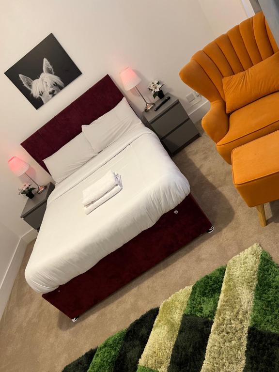 ein kleines Schlafzimmer mit einem Bett und einem Stuhl in der Unterkunft Spacious 2 bedrooms Apartment Woolwich Arsenal in Woolwich