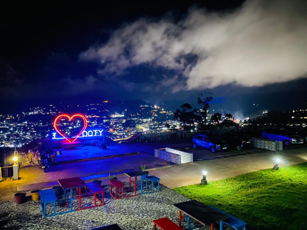a neon heart sign in a parking lot at night at Tulips Resorts - Elkhill in Ooty