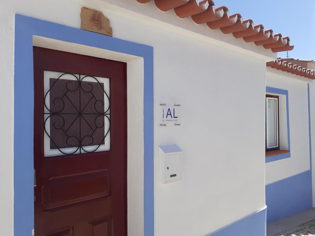 eine rote Tür mit einem Fenster auf einem Haus in der Unterkunft Alqueive GUEST HOUSE in Alqueva
