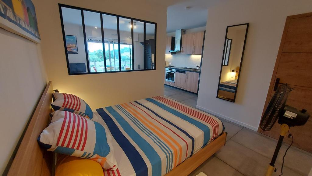 Un dormitorio pequeño con una cama y una ventana. en Mimizan-Plage - Grand Studio - 1 à 4 pers - Tout confort - 6 mn à pieds de la plage, en Mimizan-Plage