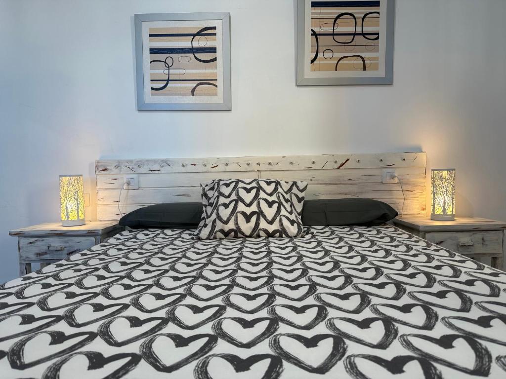 Schlafzimmer mit einem Bett mit einer schwarzen und weißen Tagesdecke in der Unterkunft Low Island House in Los Silos