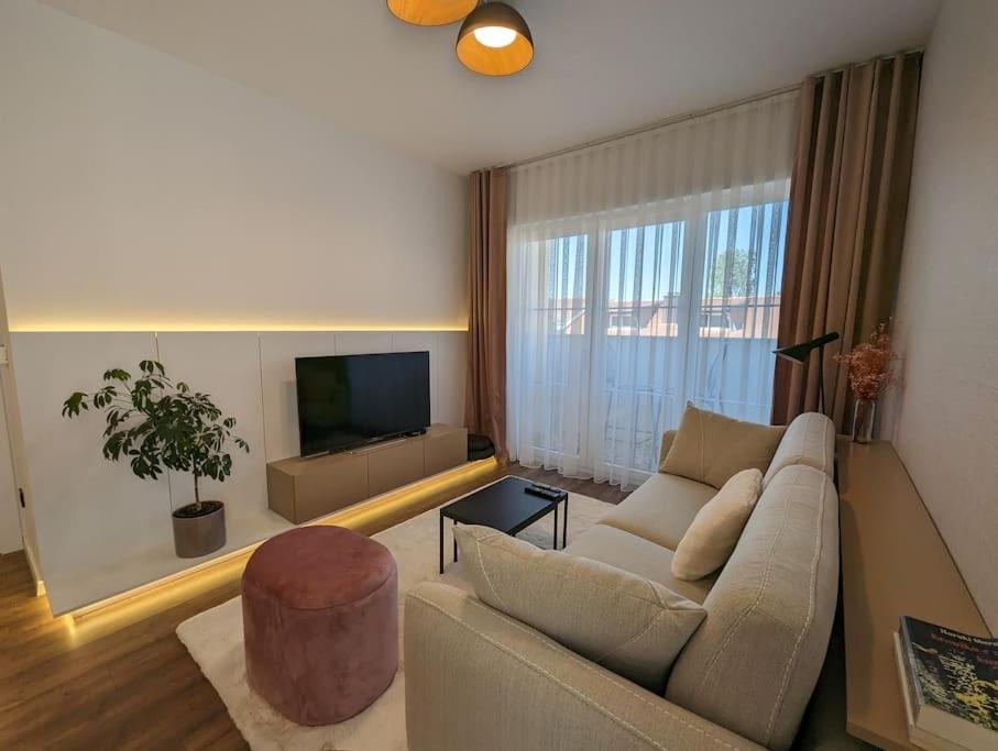 sala de estar con sofá y TV en Grandeur City Centre Apartment, en Pristina