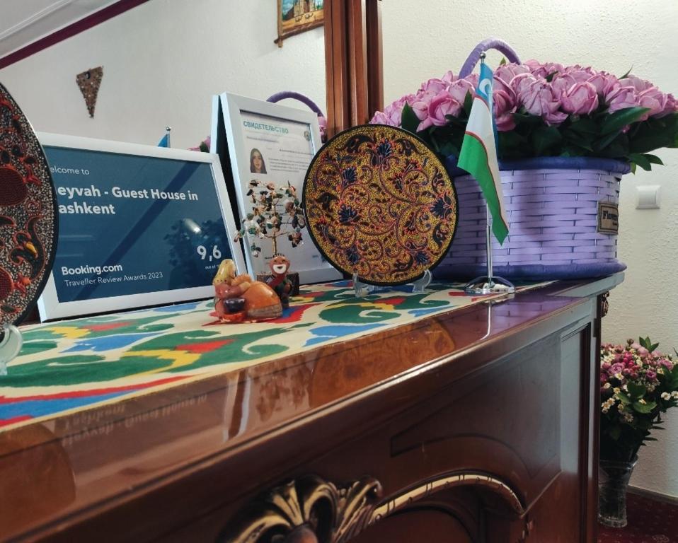 Una mesa con una cesta y flores. en Heyvah - Guest House in Tashkent, en Tashkent