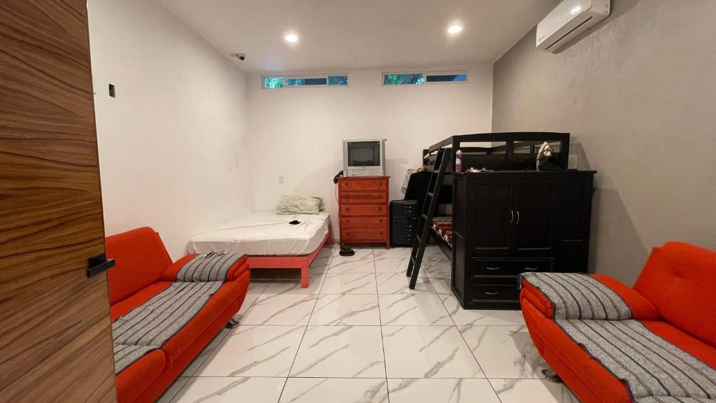 een woonkamer met 2 oranje stoelen en een bed bij tecoman colima Tamarindo in Tecomán