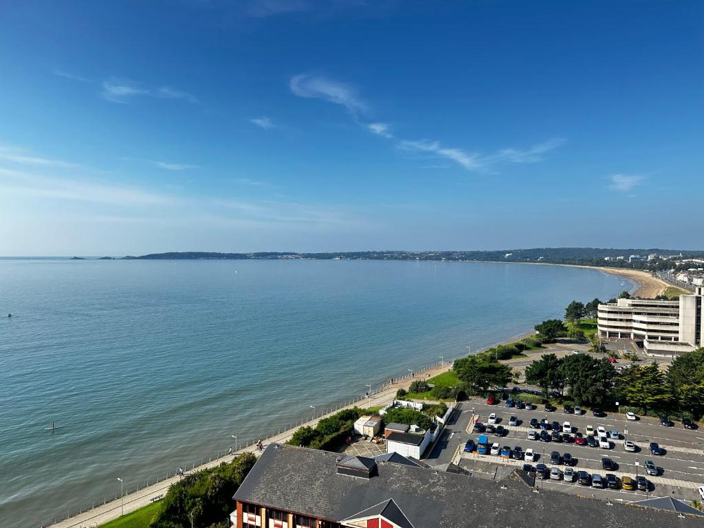 eine Luftansicht auf einen Strand mit Tischen und Stühlen in der Unterkunft Stunning Ocean & City View APT in Swansea