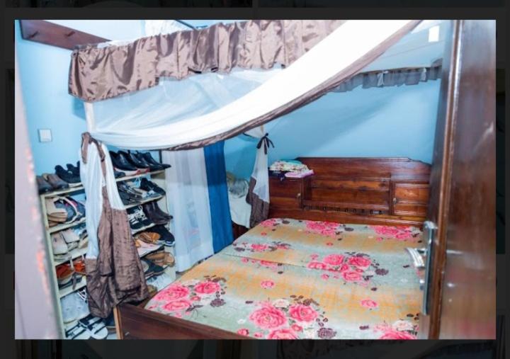 a small bedroom with a bed with a canopy at Belle Vue in Bujumbura