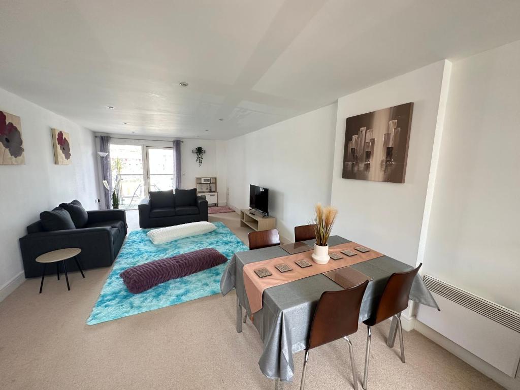 een woonkamer met een tafel en een bank bij Water Front APT Walk to the Beach & City Centre in Swansea