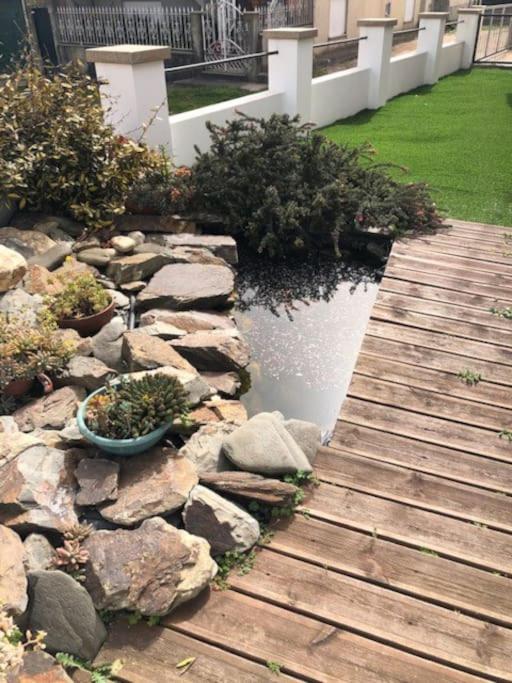 un jardín con una pasarela de madera y un estanque en Monte Carmelo Country House, 