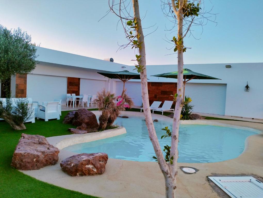 una piscina en un patio con un árbol en Villa Agate, en Midoun