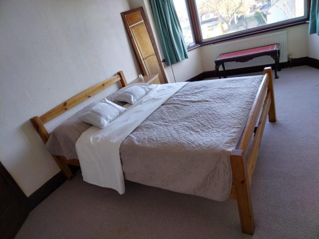 a bedroom with a large bed with white sheets and pillows at Room from home in Abbey Wood