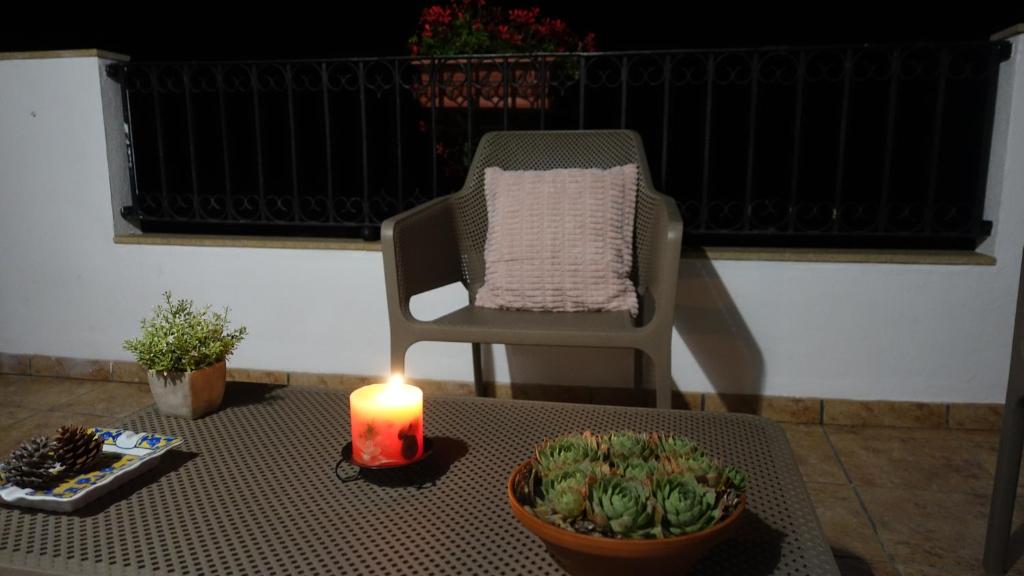 una vela sentada en una mesa junto a una silla y una planta en Casa Nieves-El retiro de los senderos en Villahermosa del Río