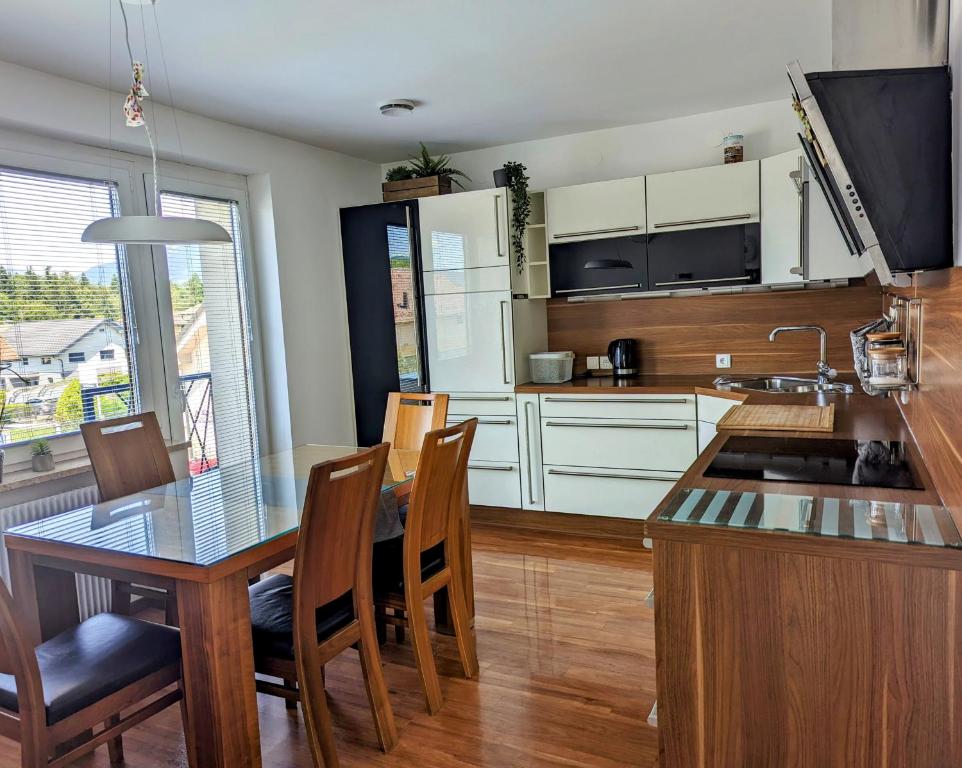 a kitchen with a table and chairs and a kitchen with white cabinets at Domen's cozy rentals in Kranj