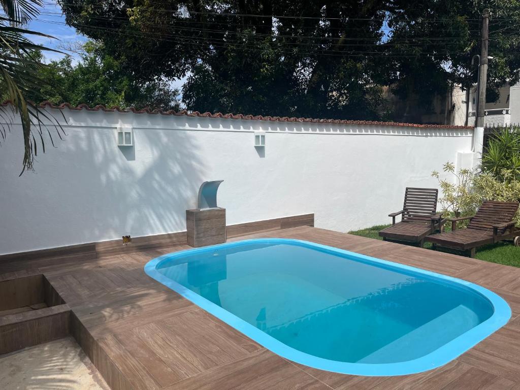 een zwembad in een achtertuin met een houten terras bij Casa em mangaratiba in Mangaratiba