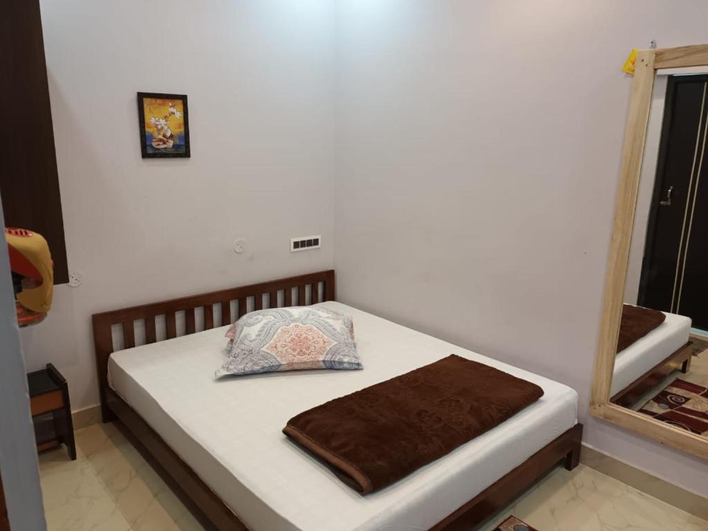 a bed with a brown blanket and a mirror at GOVARDHAN HOME STAY ( Munna ) in Guwahati