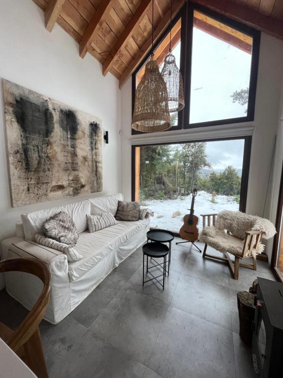 sala de estar con sofá blanco y ventana grande en Casa Silente en San Carlos de Bariloche